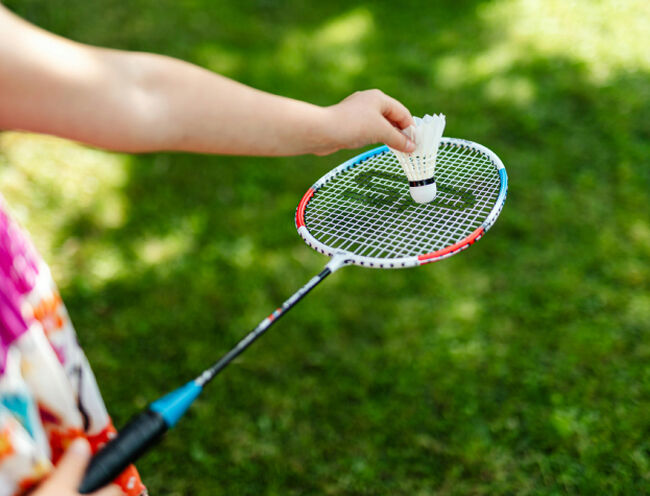 person positioning shuttlecock on badminton racket